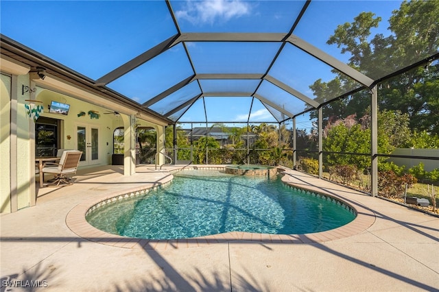 view of pool featuring a patio, french doors, glass enclosure, and a pool with connected hot tub