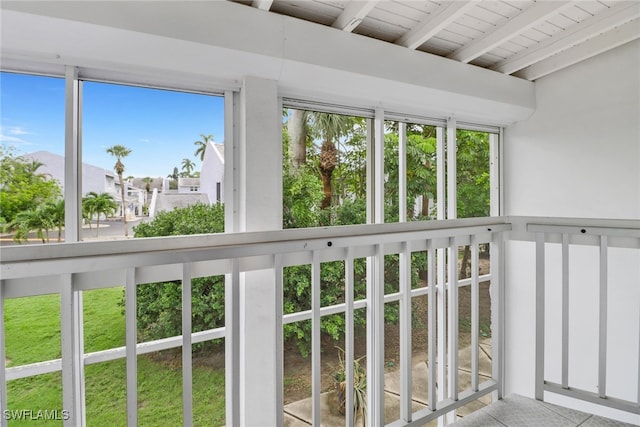 unfurnished sunroom featuring plenty of natural light, wooden ceiling, and beamed ceiling