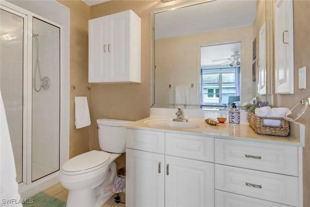 bathroom with a shower with door, vanity, ceiling fan, and toilet