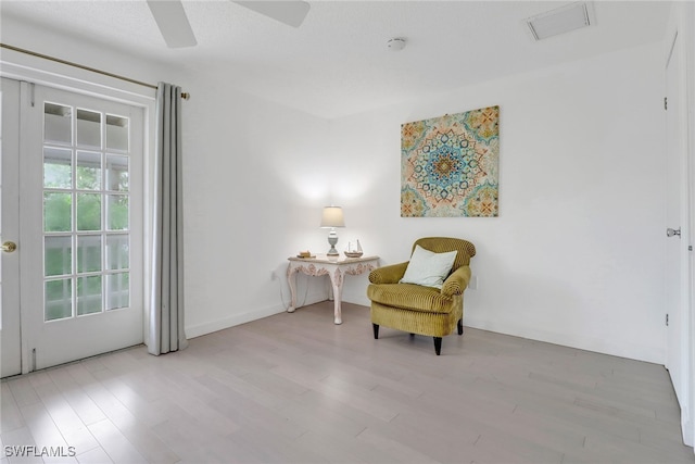 sitting room with ceiling fan and light hardwood / wood-style flooring