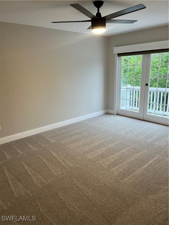 carpeted spare room featuring ceiling fan