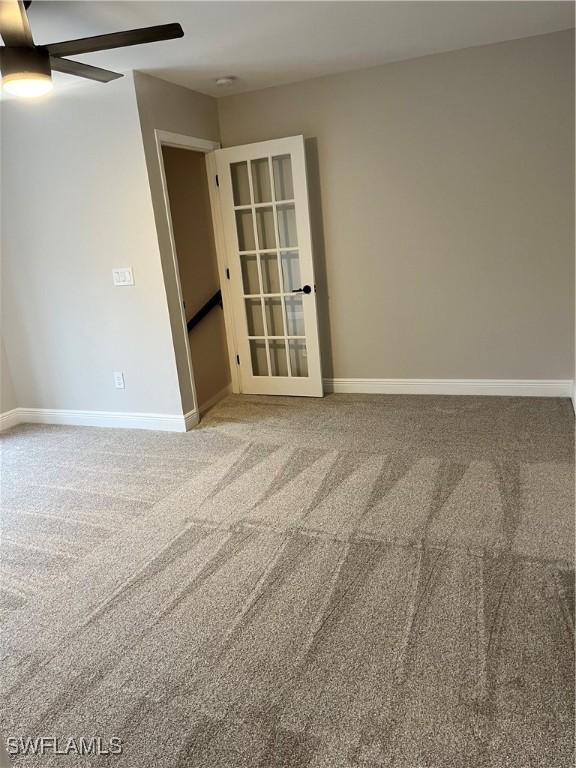 empty room with ceiling fan and carpet floors