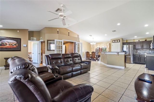 tiled living room featuring vaulted ceiling and ceiling fan with notable chandelier