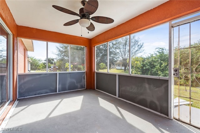 unfurnished sunroom featuring ceiling fan and a wealth of natural light