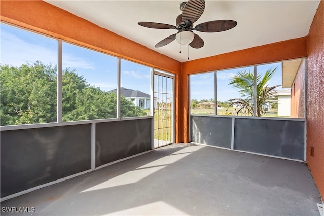 unfurnished sunroom featuring ceiling fan