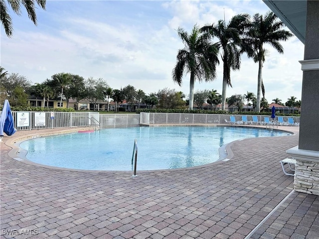 community pool with fence and a patio