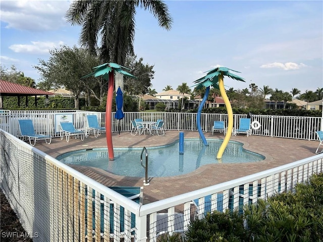 view of swimming pool with a patio area and fence