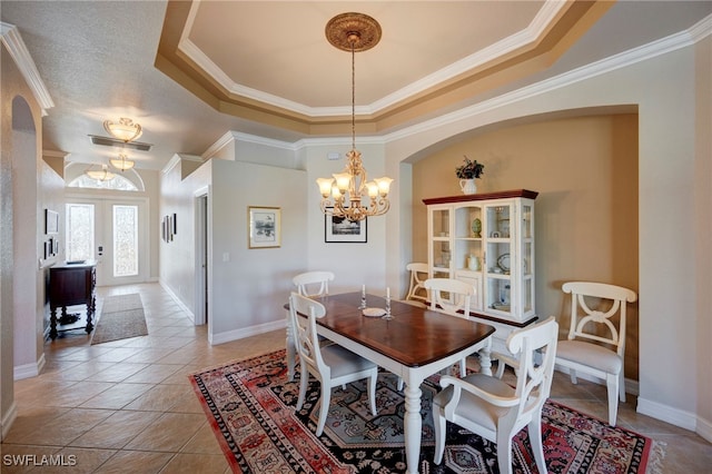 dining space featuring arched walkways, light tile patterned flooring, a notable chandelier, french doors, and a raised ceiling