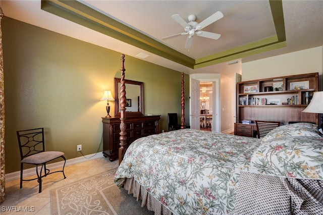 bedroom featuring light tile patterned floors, baseboards, visible vents, and a raised ceiling