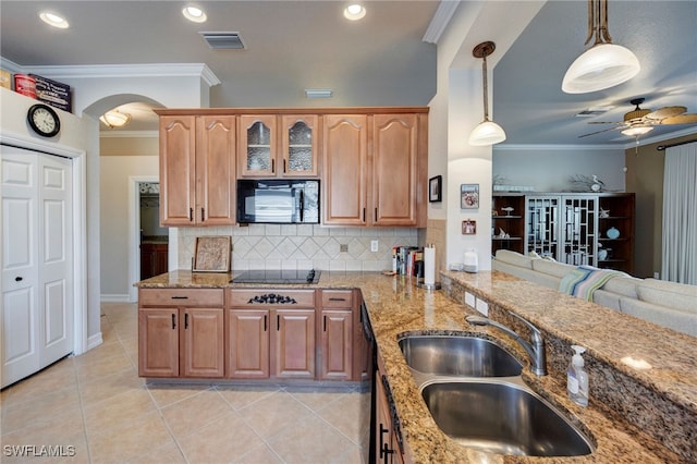 kitchen with visible vents, ornamental molding, light stone countertops, black appliances, and a sink