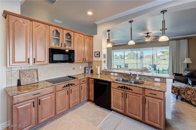 kitchen featuring decorative backsplash, open floor plan, a peninsula, black appliances, and a sink