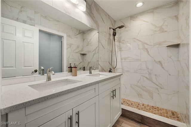 bathroom featuring a tile shower and vanity