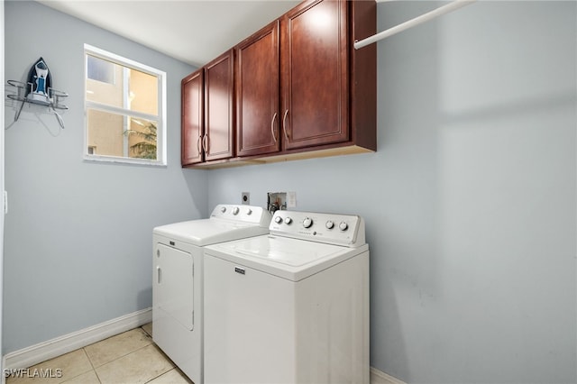 laundry area featuring cabinets, separate washer and dryer, and light tile patterned floors