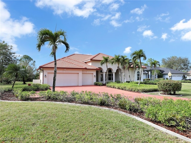 mediterranean / spanish-style home with a garage and a front yard