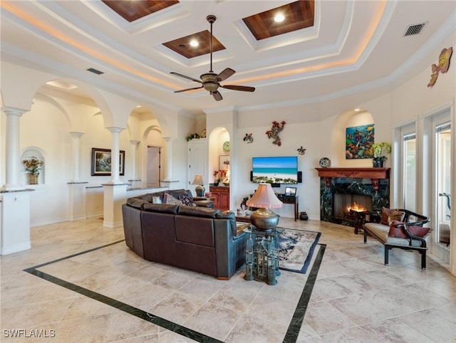 living room with crown molding, a high end fireplace, and decorative columns