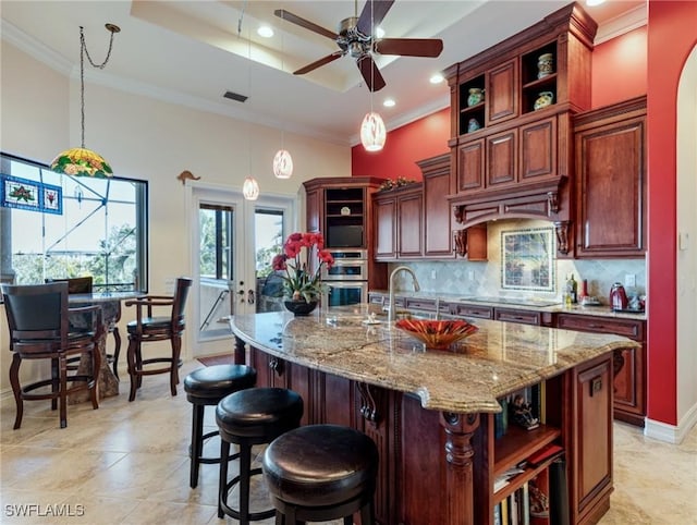 kitchen with pendant lighting, ornamental molding, black electric cooktop, decorative backsplash, and a raised ceiling