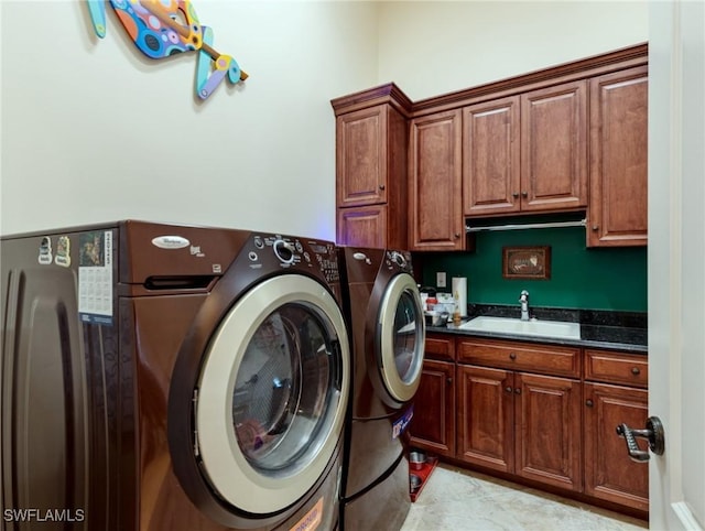 washroom with sink, washer and clothes dryer, and cabinets