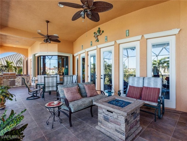 view of patio / terrace featuring an outdoor kitchen, a grill, ceiling fan, and an outdoor fire pit