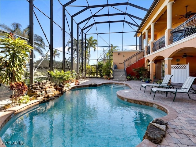 view of pool featuring a patio area, ceiling fan, and glass enclosure