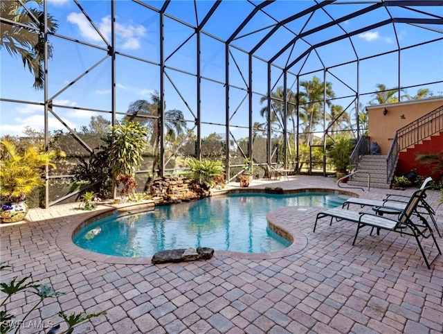 view of swimming pool with a lanai and a patio