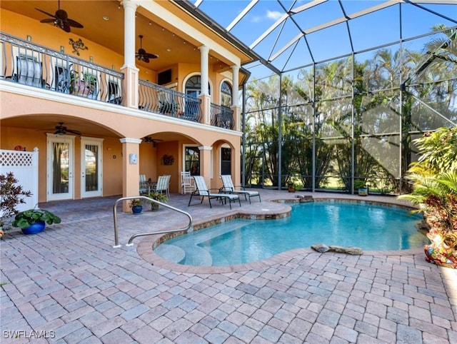 view of pool with ceiling fan, a patio, and glass enclosure