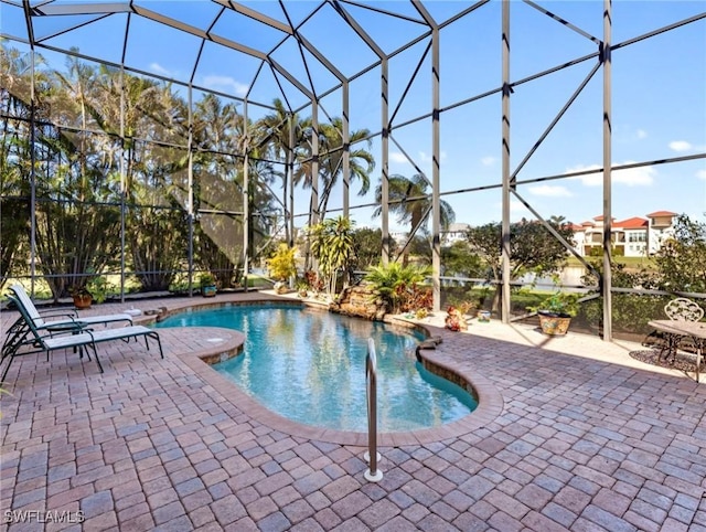 view of swimming pool with a patio area and glass enclosure