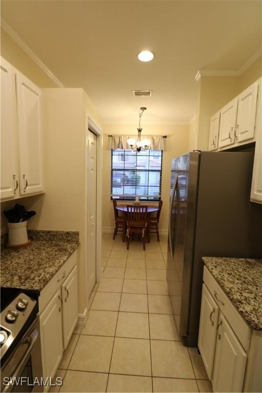 kitchen with white cabinetry, stainless steel refrigerator, dark stone counters, and range