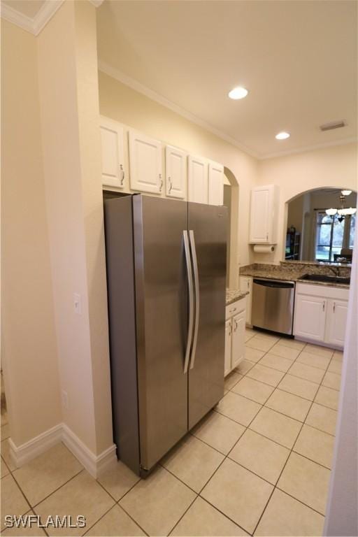 kitchen with crown molding, appliances with stainless steel finishes, light tile patterned floors, and white cabinets