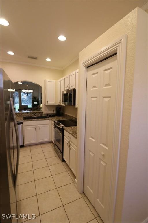 kitchen featuring sink, white cabinetry, crown molding, light tile patterned floors, and appliances with stainless steel finishes