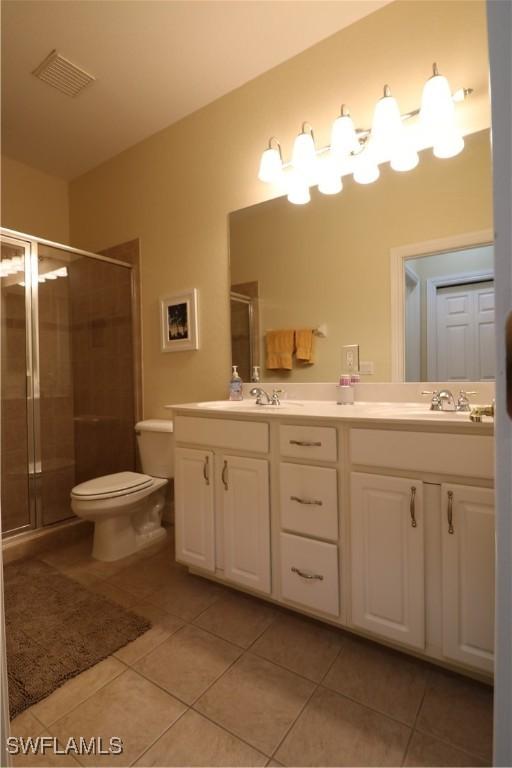 bathroom with tile patterned flooring, vanity, and an enclosed shower