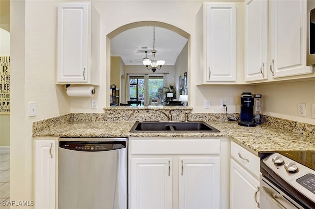 kitchen with white cabinetry, a sink, arched walkways, and stainless steel appliances