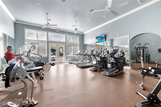 exercise room featuring crown molding, a towering ceiling, ceiling fan, and french doors