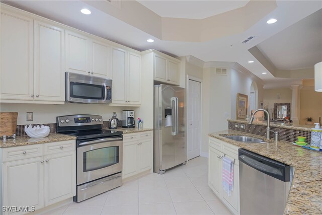 kitchen featuring sink, white cabinetry, stainless steel appliances, light stone countertops, and light tile patterned flooring