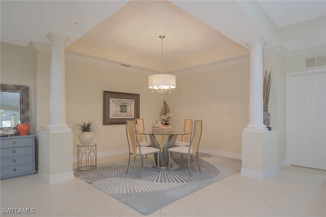 dining room with crown molding, a tray ceiling, decorative columns, and light tile patterned floors