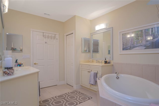 bathroom featuring tile patterned floors, vanity, and tiled tub