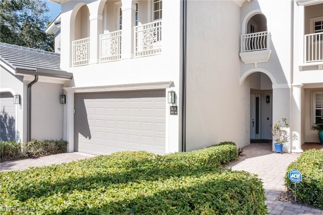 property entrance featuring an attached garage and stucco siding