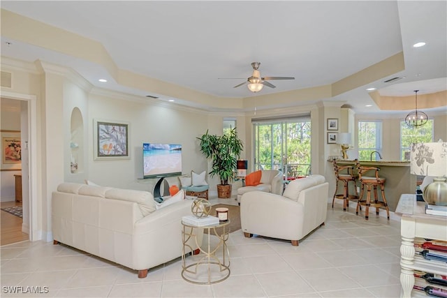 living room featuring a raised ceiling, crown molding, light tile patterned floors, and recessed lighting