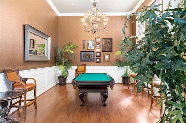 recreation room with wainscoting, wood finished floors, and crown molding