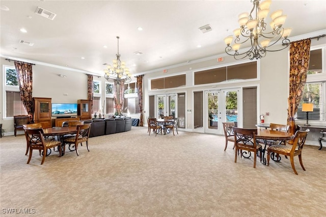 dining room featuring light colored carpet, an inviting chandelier, french doors, and visible vents