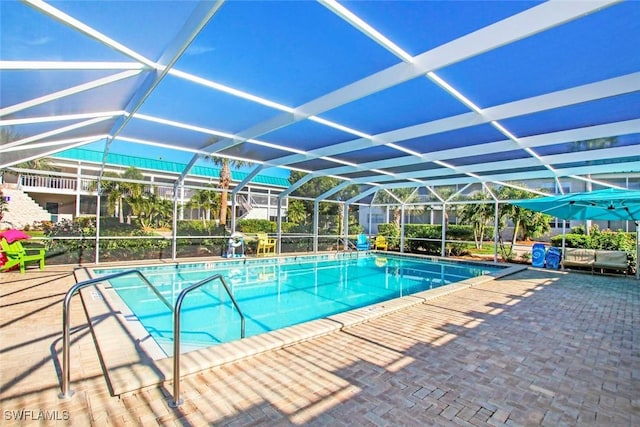 view of swimming pool featuring a lanai and a patio