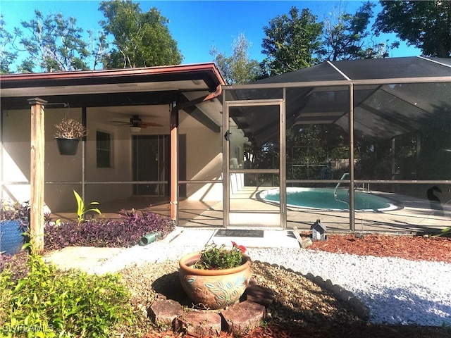 rear view of house featuring ceiling fan, a patio, and glass enclosure