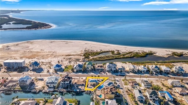 bird's eye view with a water view and a beach view