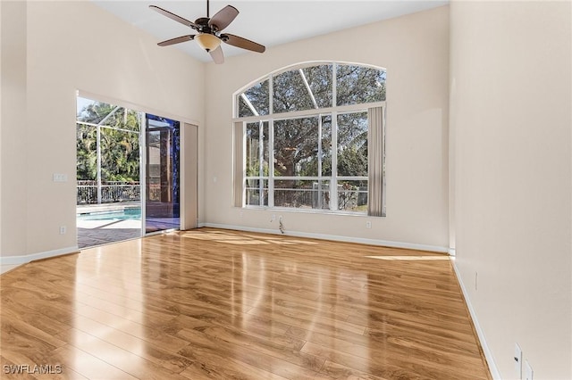 unfurnished room with ceiling fan, baseboards, and wood finished floors