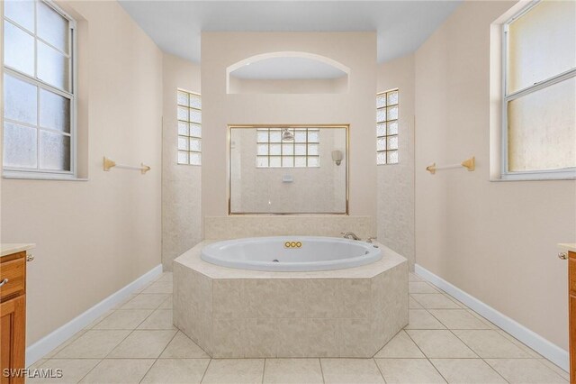 bathroom featuring tile patterned floors, vanity, and tiled tub