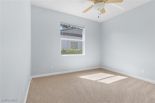 carpeted empty room featuring ceiling fan and baseboards