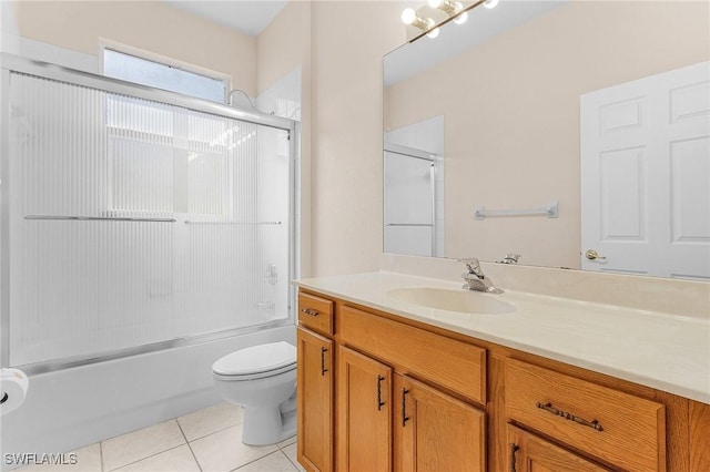 bathroom with tile patterned flooring, vanity, toilet, and bath / shower combo with glass door