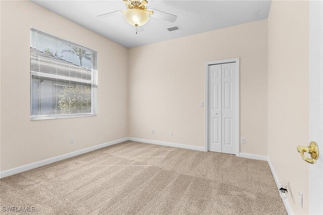 unfurnished room with ceiling fan and light colored carpet