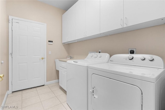 laundry area featuring cabinet space, washer and clothes dryer, baseboards, and light tile patterned floors