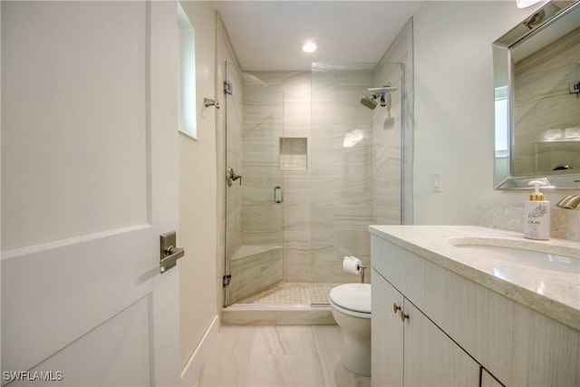 bathroom featuring vanity, an enclosed shower, and toilet