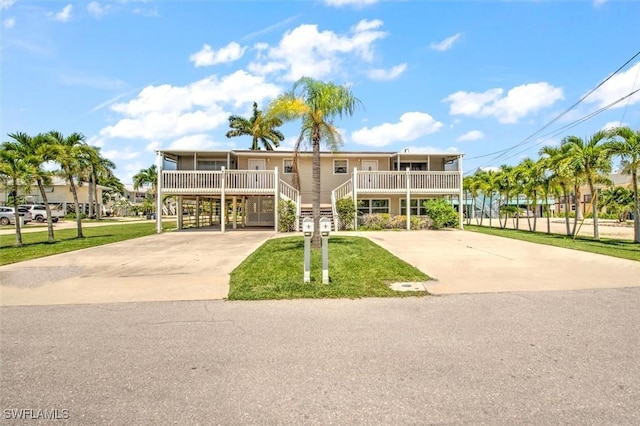 view of front of home with a carport, covered porch, and a front lawn